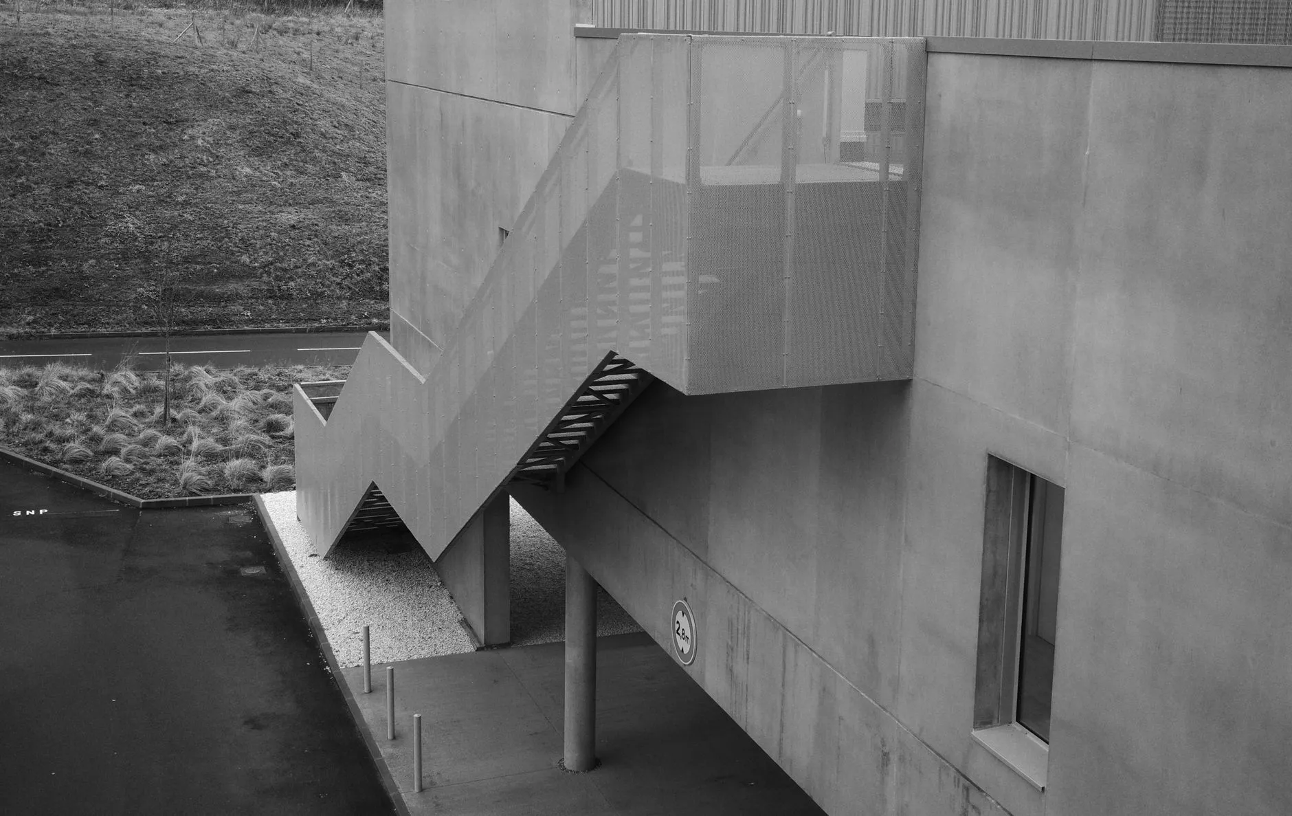 A concrete facade stepping back in flat daylight